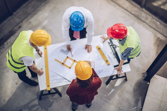 Engineers and builders discussing building plan for construction project