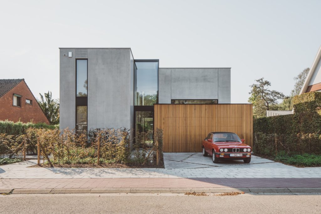 A concrete house with a car infront