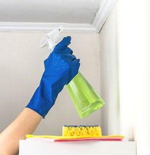 Spraying cleaning solution on popcorn ceiling
