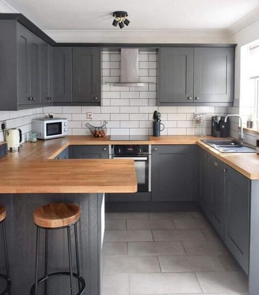 Grey and white dirty kitchen design with wooiden countertop