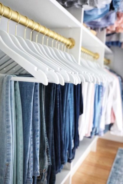 Color coordinated pants arranged in hangers in closet