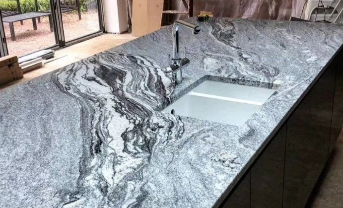 a granite countertop with a sink and faucet