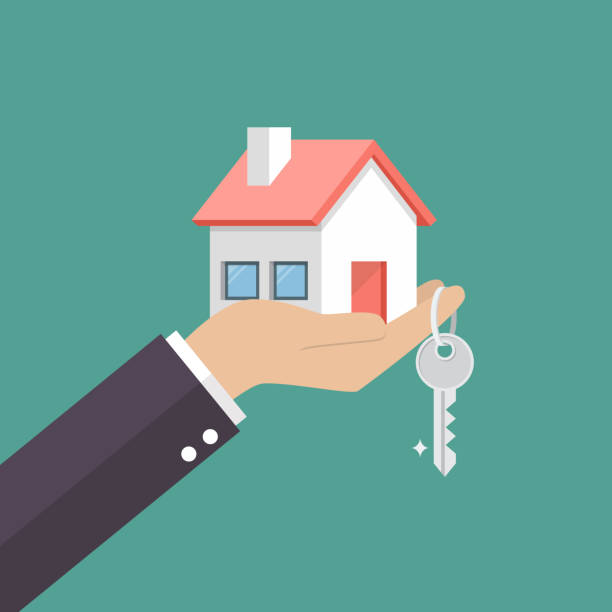 Hand holding out a house and key to illustrate ownership of property
