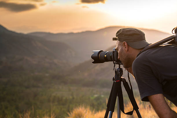 A cameraman with tripod and cam shooting on hills