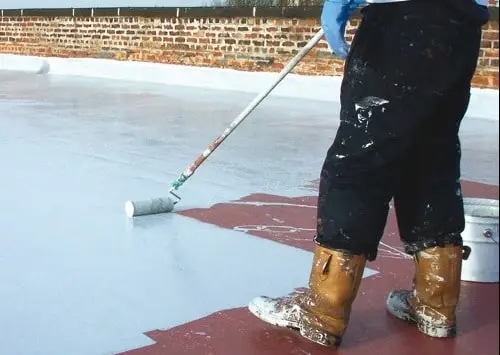 a worker applying coat of Liquid Waterproofing Membrane on the floor