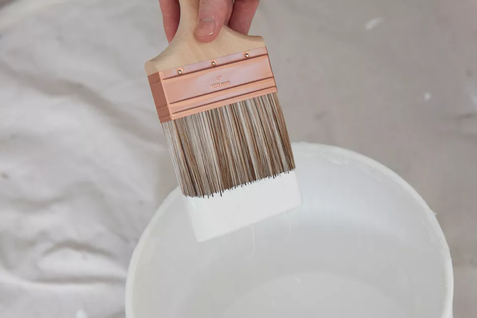 a paint bucket with a paintbrush