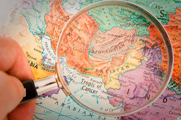 Photograph of Afghanistan, Pakistan and surrounding countries on retro globe underneath a magnifying glass."