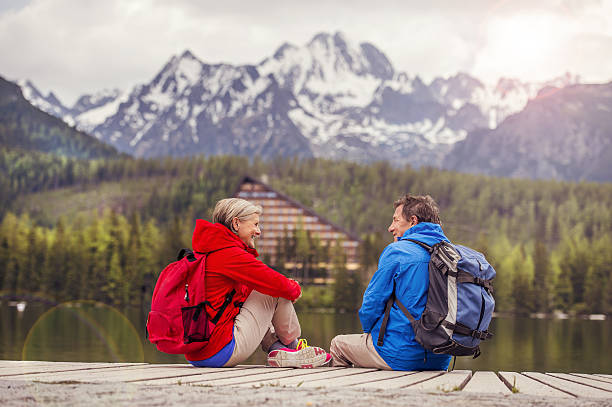 پہاڑی علاقے میں جھیل کے قریب بیٹھے دو سیاح