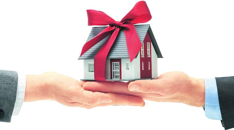 A hand places a gift wrapped house on another hand