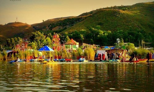 Kallar kahar lake with a backdrop of people enjoying with family