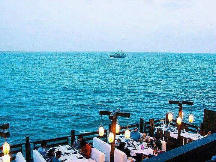 A view from Kolachi of the sea and people dining in the restaurant