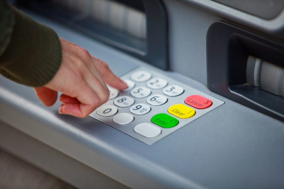 cropped hand of man using atm