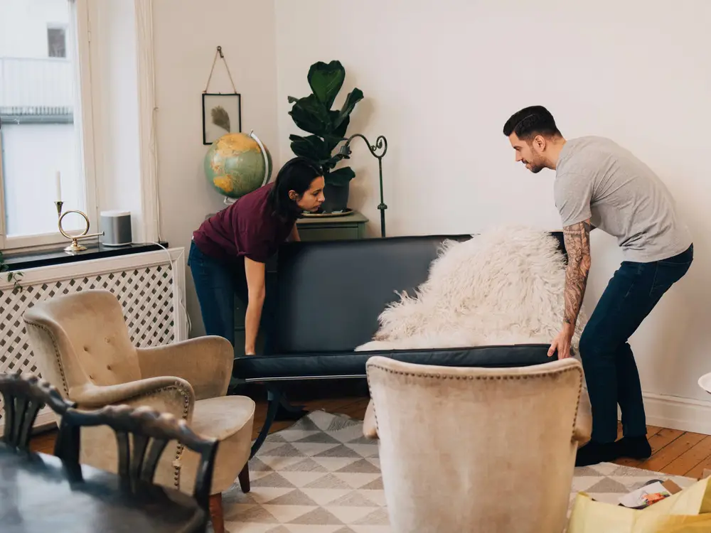 couple rearranging furniture 