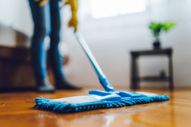 خاتون گھر میں فرش کی صفائی کرتے ہوئے
