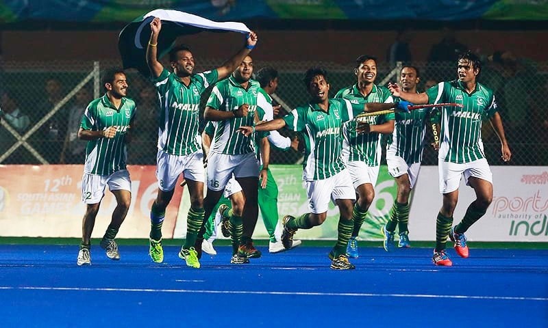 Pakistani hockey team players celebrating a victory with Pakistani national flag