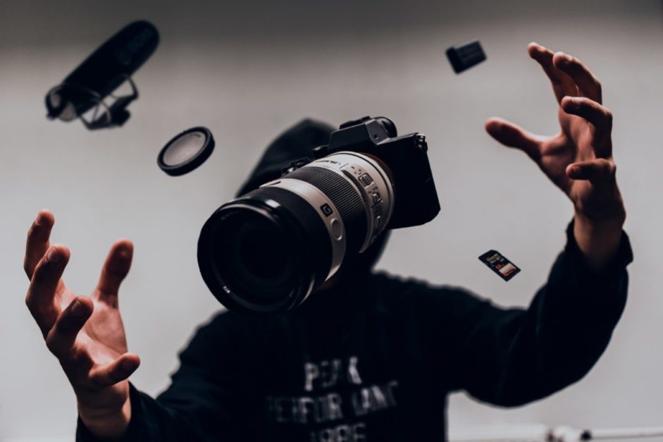 man catching DSLR camera, memory card, lens 