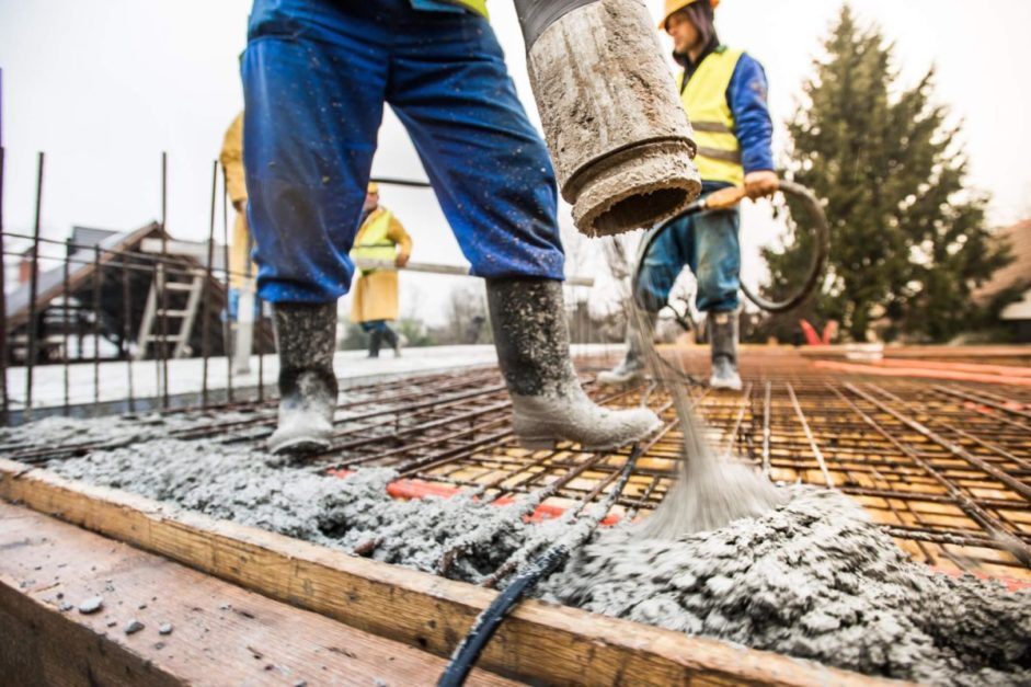 two labourers adding layer of to rebar frame