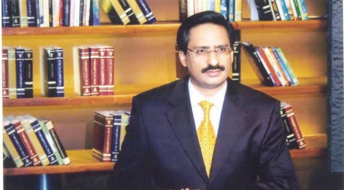Javed Chahudry sitting infront of a book shelf