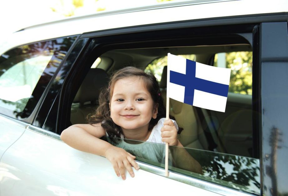 A little girl holding Finland flag