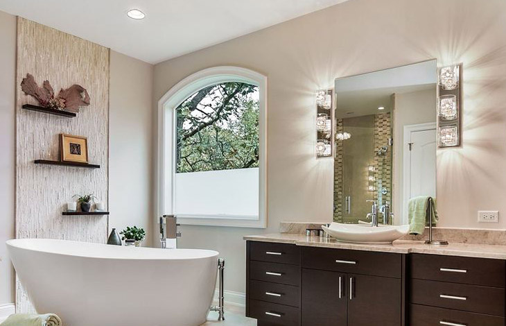 bathroom with long mirror with lighting fixtures