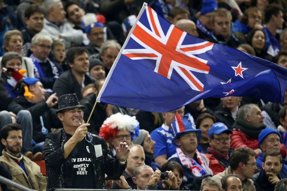 a man holding New Zealand flag