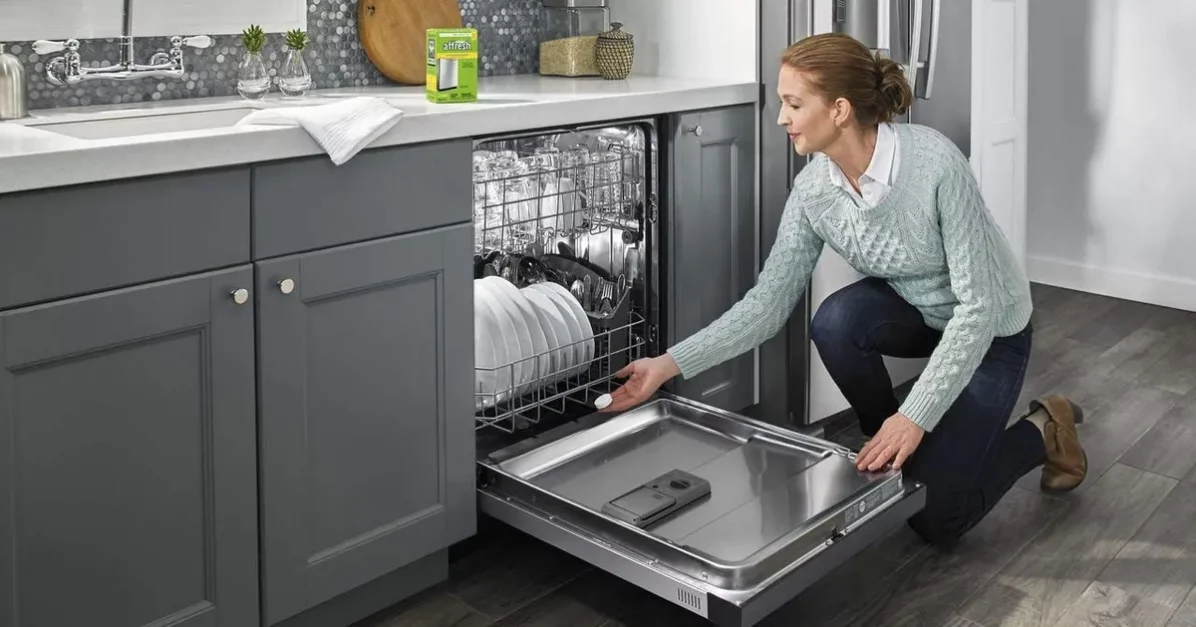 A woman placing dishes in a dishwasher