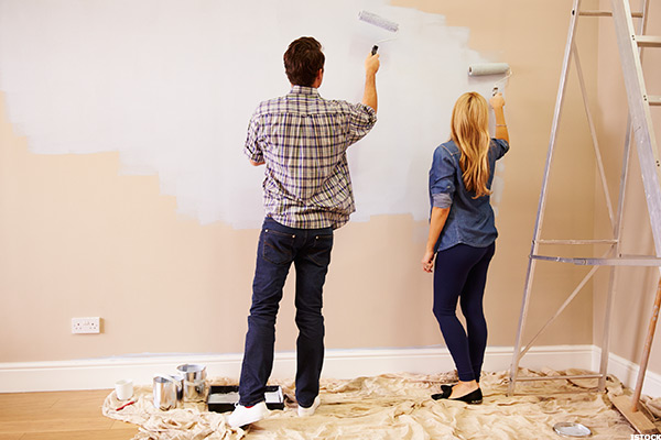 man and women Painting a wall of a room