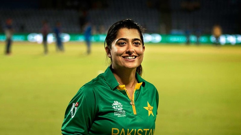 Sana Mir posing in a cricket kit