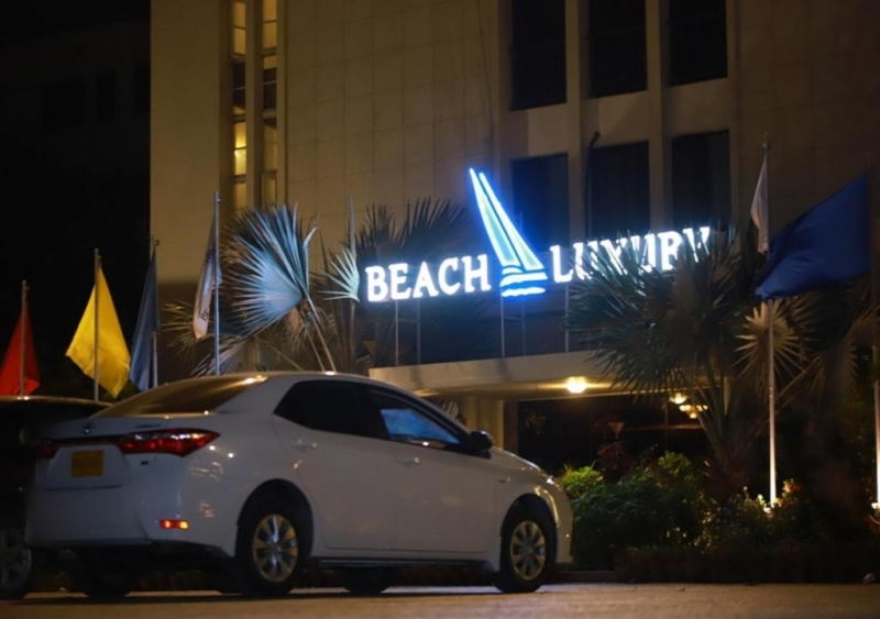 A night view of Beach Luxury Hotel Karachi with car parked outside