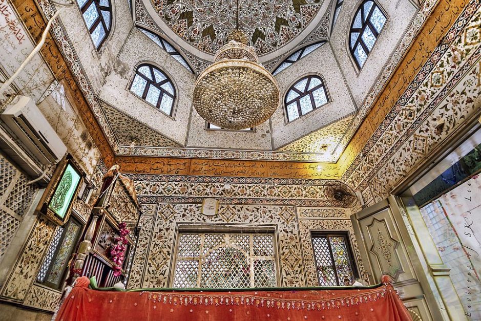 The tomb is a square-shaped building with a domed ceiling embellished with intricate calligraphy and designs