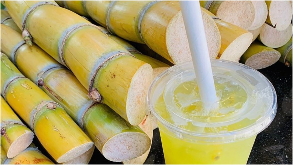 Sugar cane juice in a glass with sugar cane pack on the side