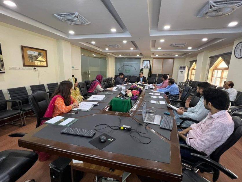 people sitting areound a table in a meeting room at PMF Lahore