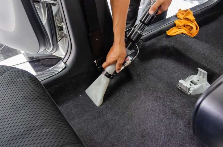 A man cleaning car carpet