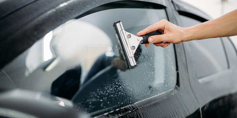 Man cleaning his car's windows with viper