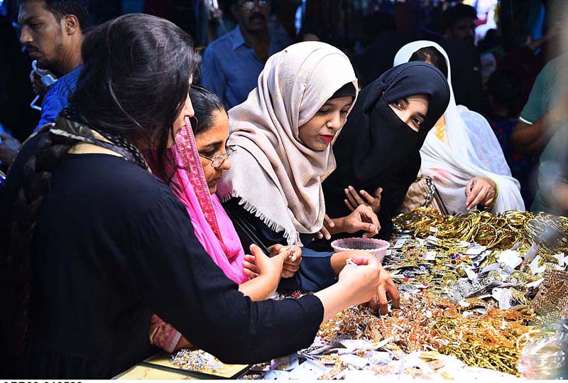 Women busy in selecting and purchasing artificial jewellery for preparation of Eid-ul-Fitr at Hyderi Market.