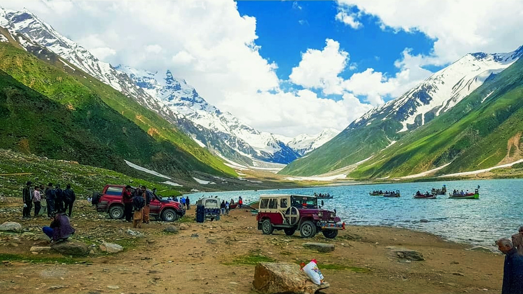 visitors at Saif ul Malook Lake with their jeeps parked there