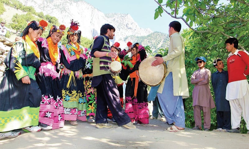 people drumming and dancing at the festival of kalash valley