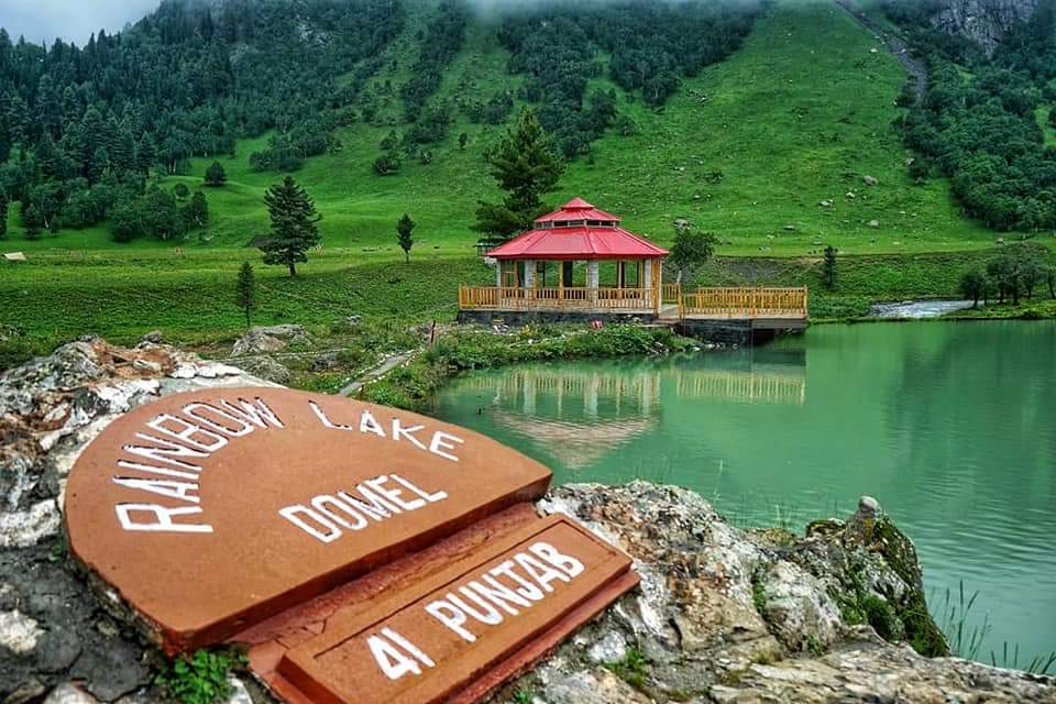 A sign of Rainbow Lake Minimarg near water