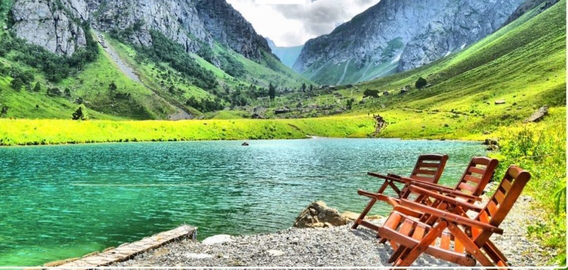 2 chairs near water and the view of mountains