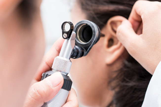 a doctor checking up the inside of the patients ear