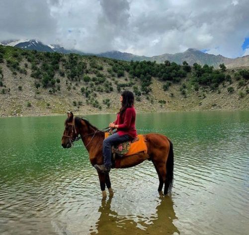 A girl on a horse at rama lake astore