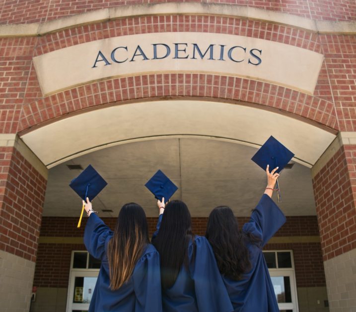 students tossing graduation caps